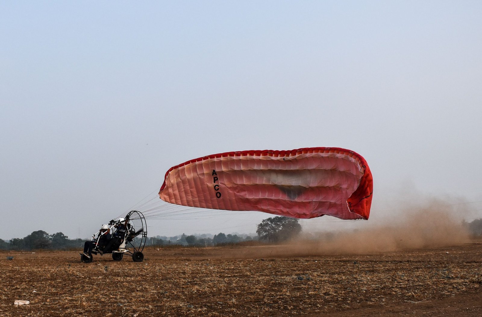 Tandem Paramotor Trike Accelerating across Sand Runway into Lift