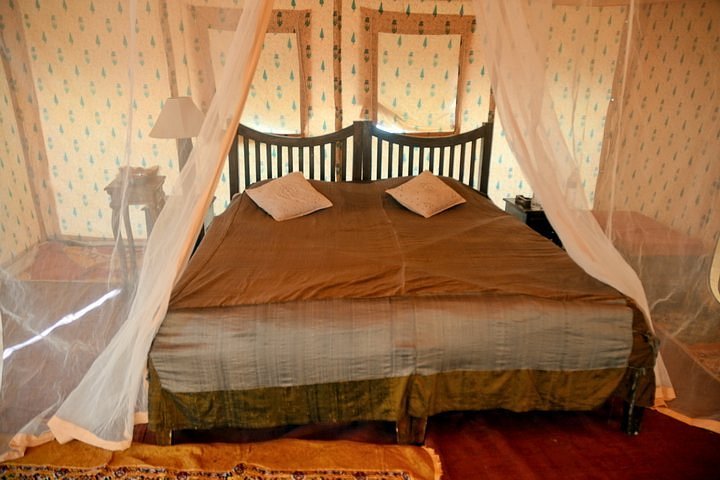 Royal Heritage AC Desert Tent Interior with Carved Teakwood Bed and Climate Control in Jaisalmer